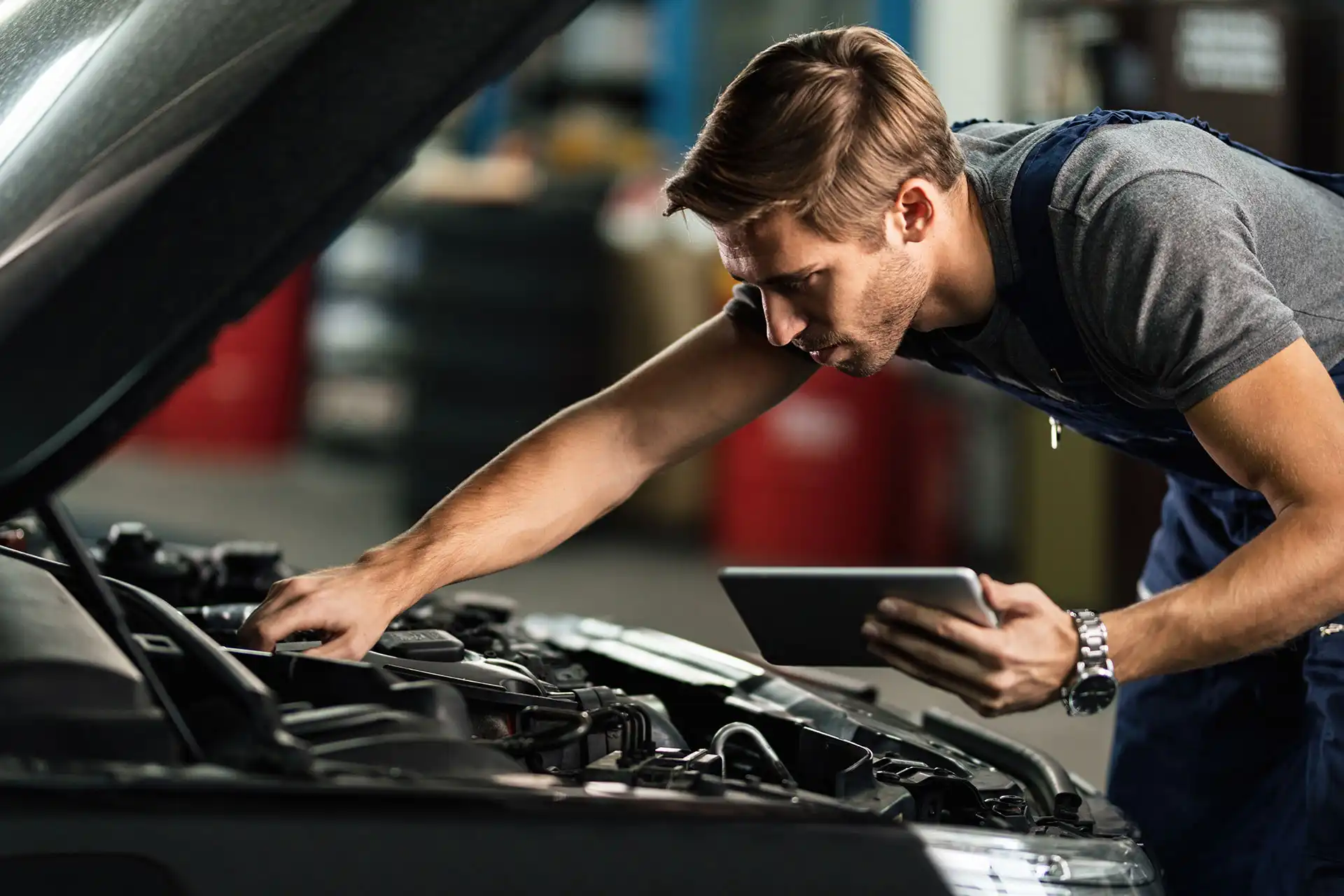 Meccanico che diagnostica un problema al motore utilizzando un tablet per analizzare i dati in tempo reale