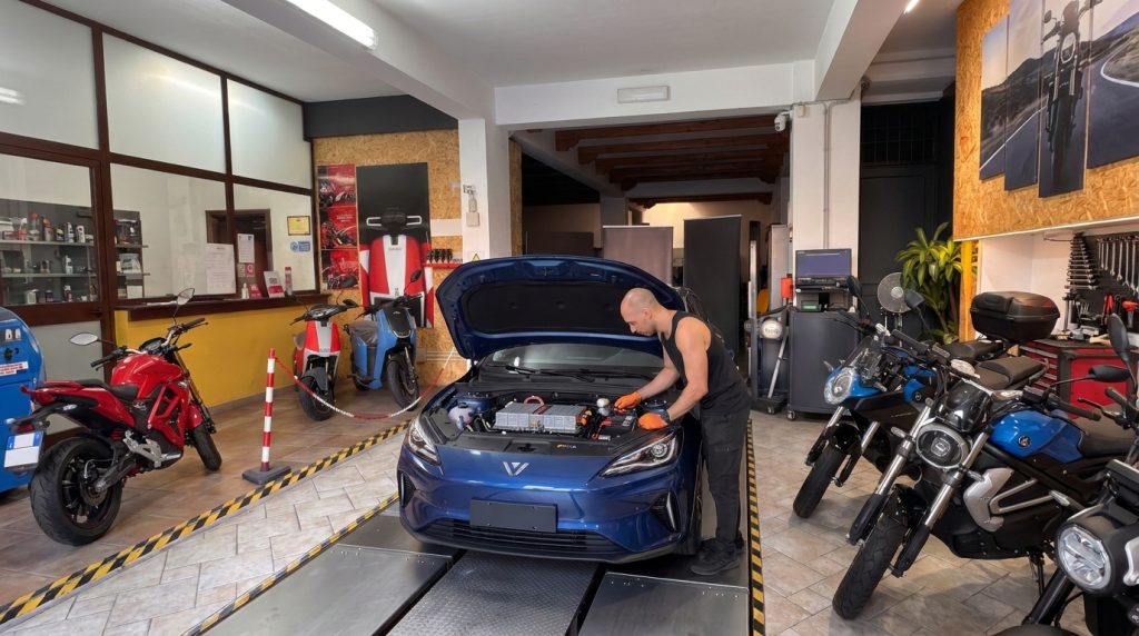 Tecnico che lavora su una MG MG3 Hybrid blu all'interno di un'officina meccanica